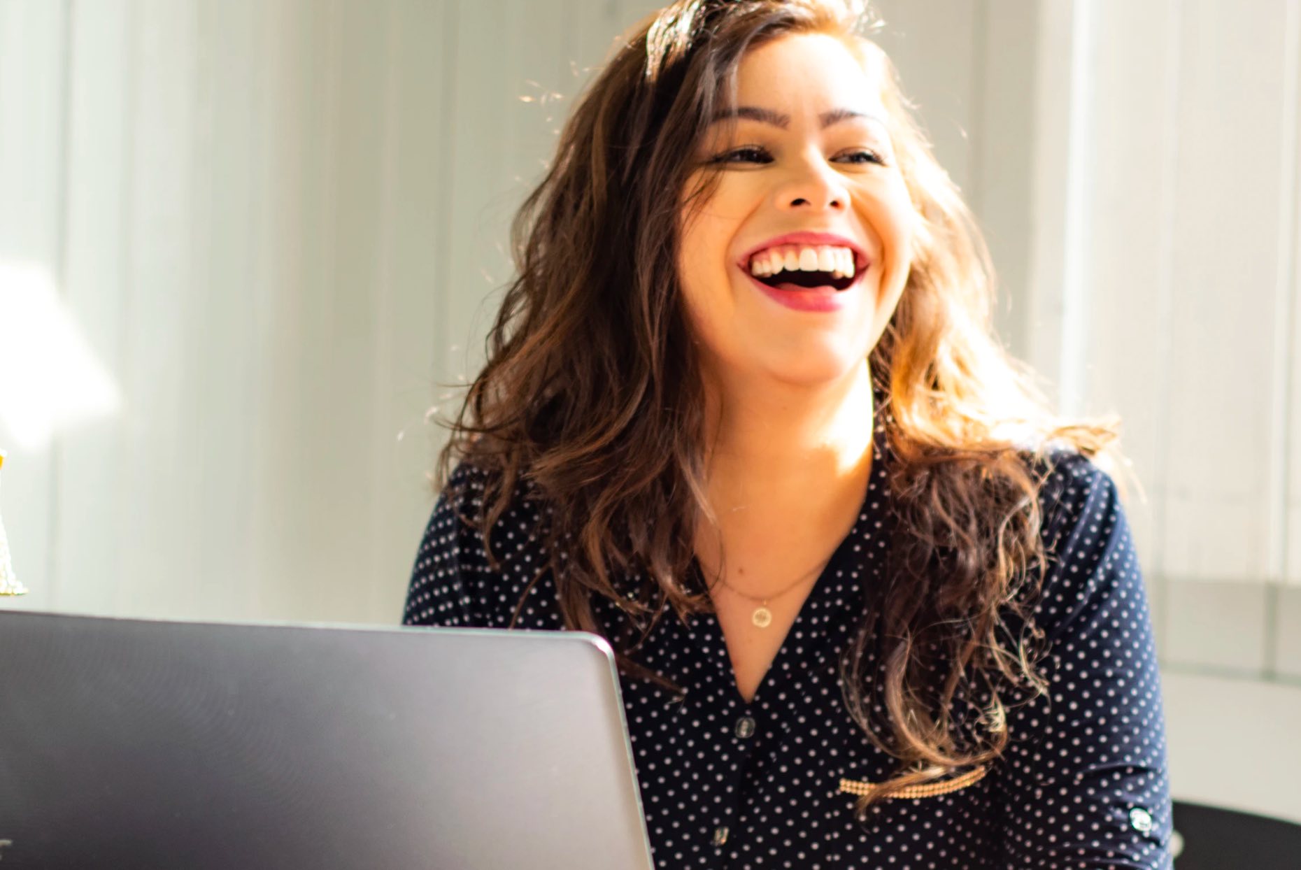 woman at desk laughing